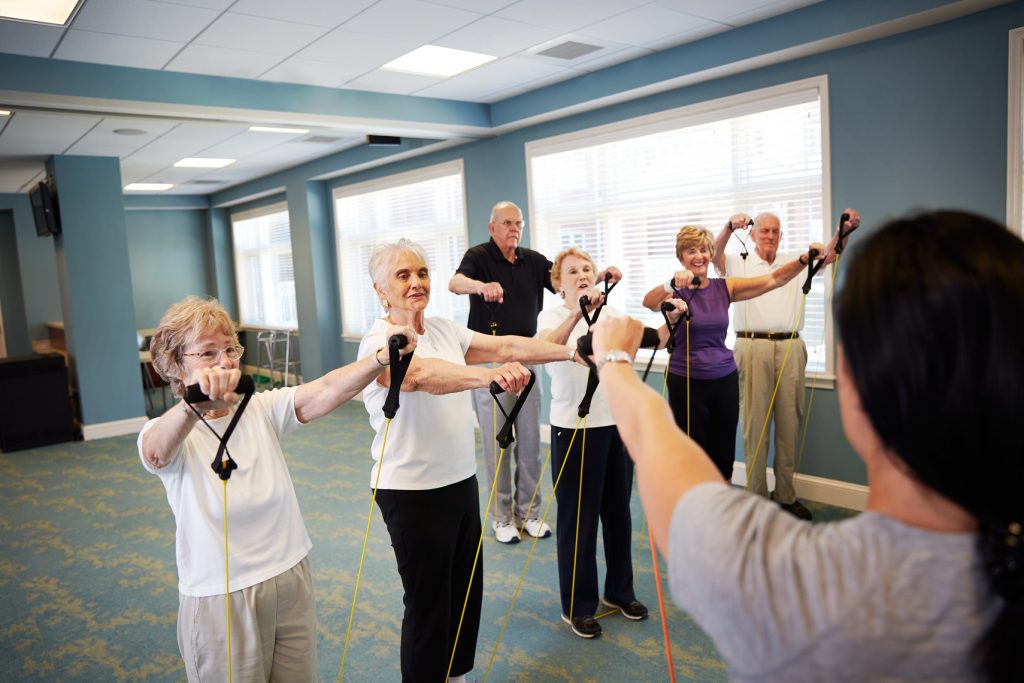 Ginger Cove residents attending a fitness class with band exercise