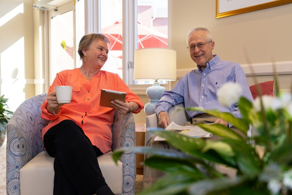 Ginger Cove residents enjoying coffee with a newspaper in armchairs