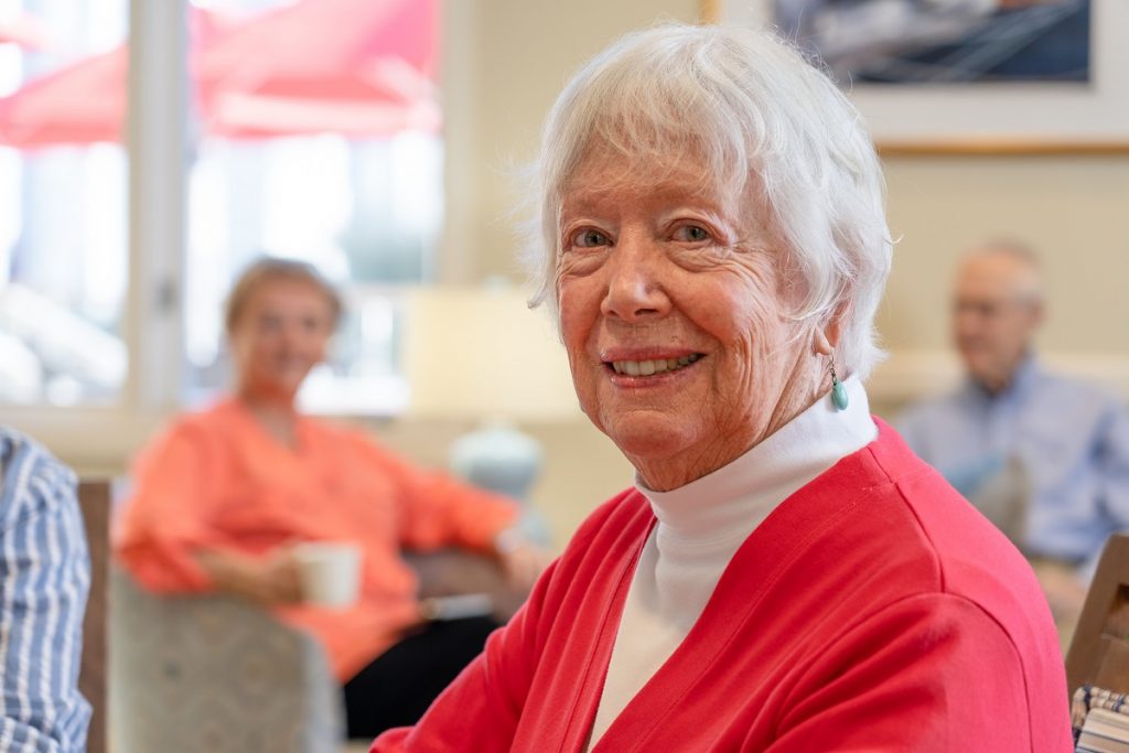 Portrait of Ginger Cove resident, a senior woman wearing red