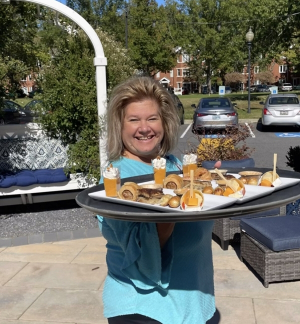 Ginger Cove employee serving platter of food outdoors