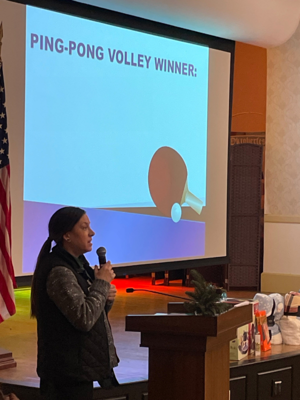 Ginger Cove employee announcing ping-pong volley winner