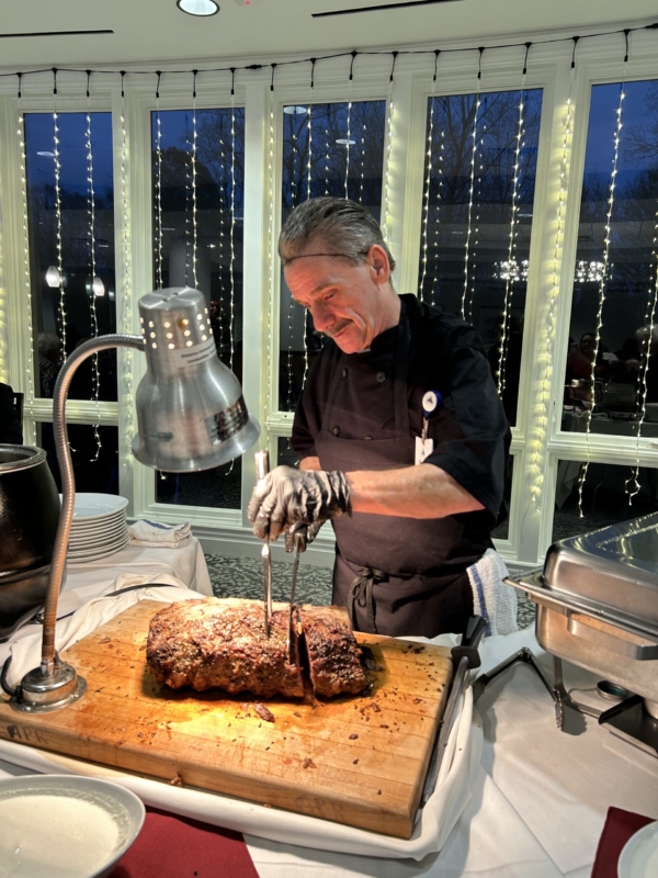 Ginger Cove employee carving meat at Christmas party