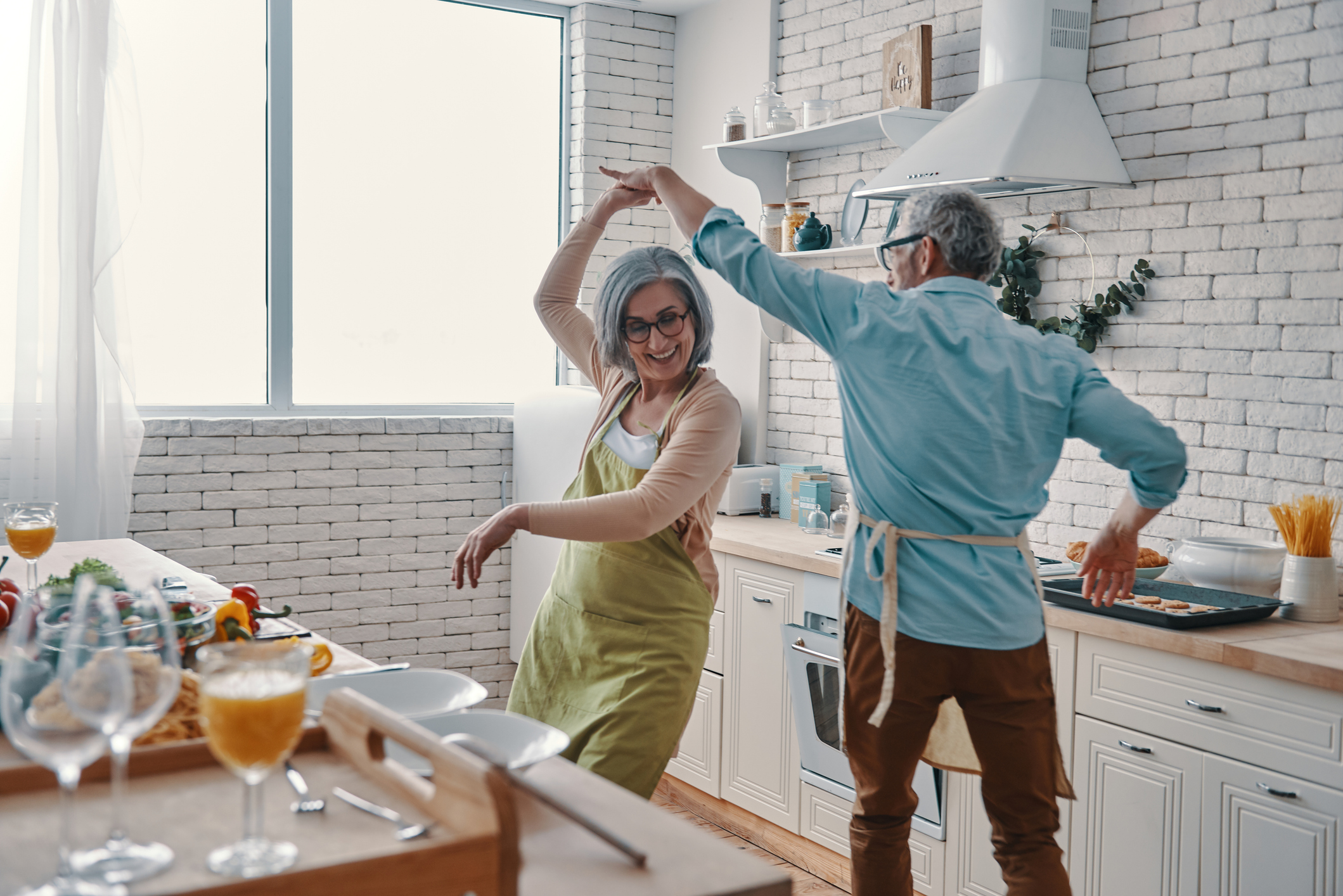Beautiful playful senior couple Seniors dancing in the kitchen