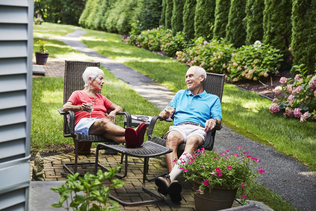 Ginger Cove residents reclining and chatting on their patio