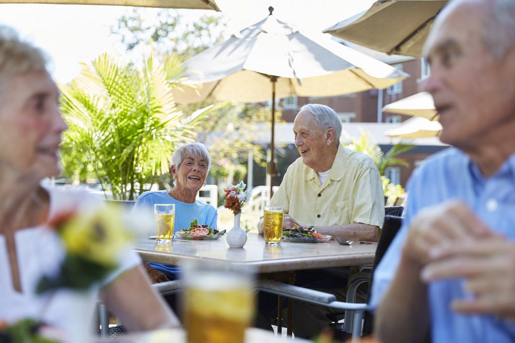 Ginger Cove residents eating salads on sunny patio