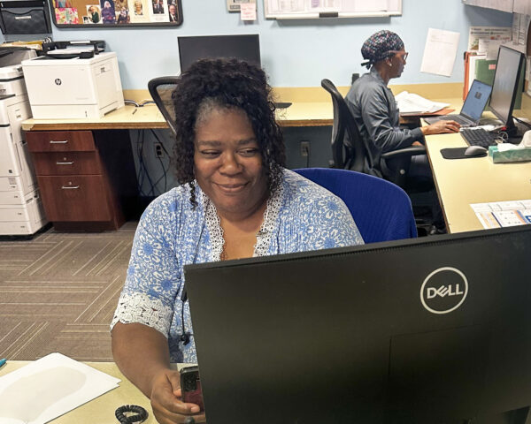 Ginger Cove nurse smiling at computer station