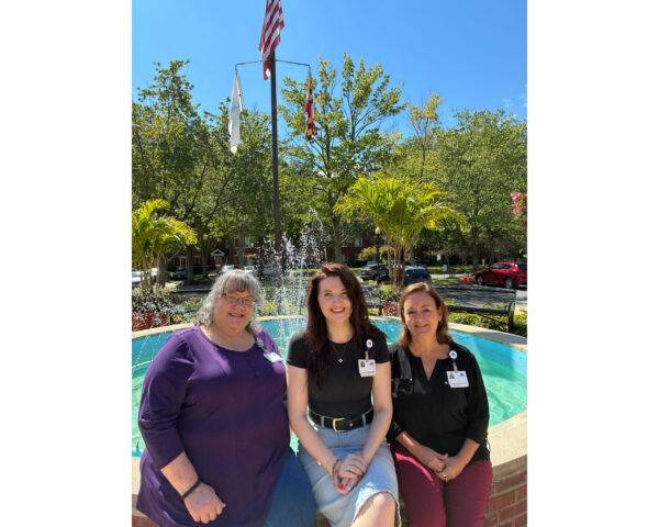 Ginger Cove employees sitting on Ginger Cove fountain edge
