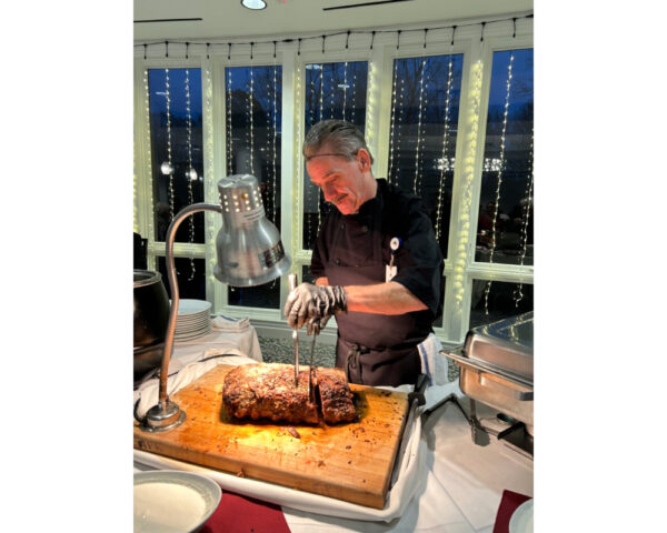 Ginger Cove employee carving meat at Christmas party