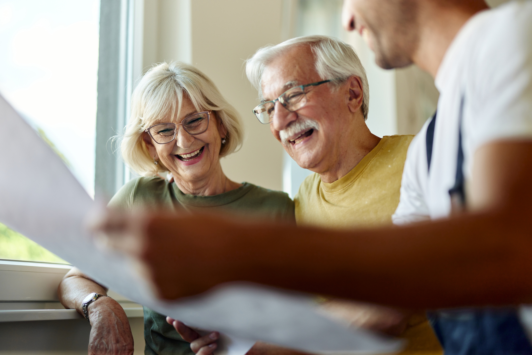 Annapolis senior couple with tablet and calculator smile while managing bills and paperwork. 